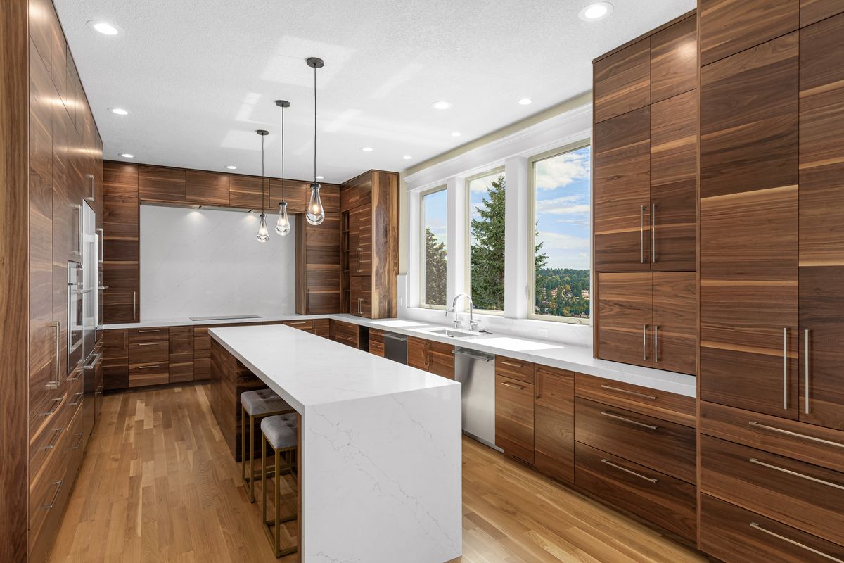 NW Skyline whole-home remodel — walnut kitchen with quartz waterfall island and hillside view